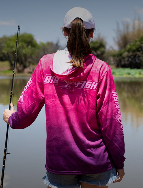 Woman wearing Aus Camo Plum Hoodie holding fishing rod by river