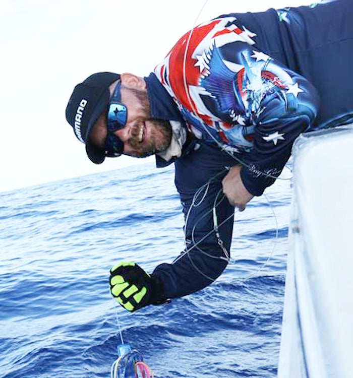 Aussie Pride Navy fishing shirt - angler leaning over boat releasing marlin