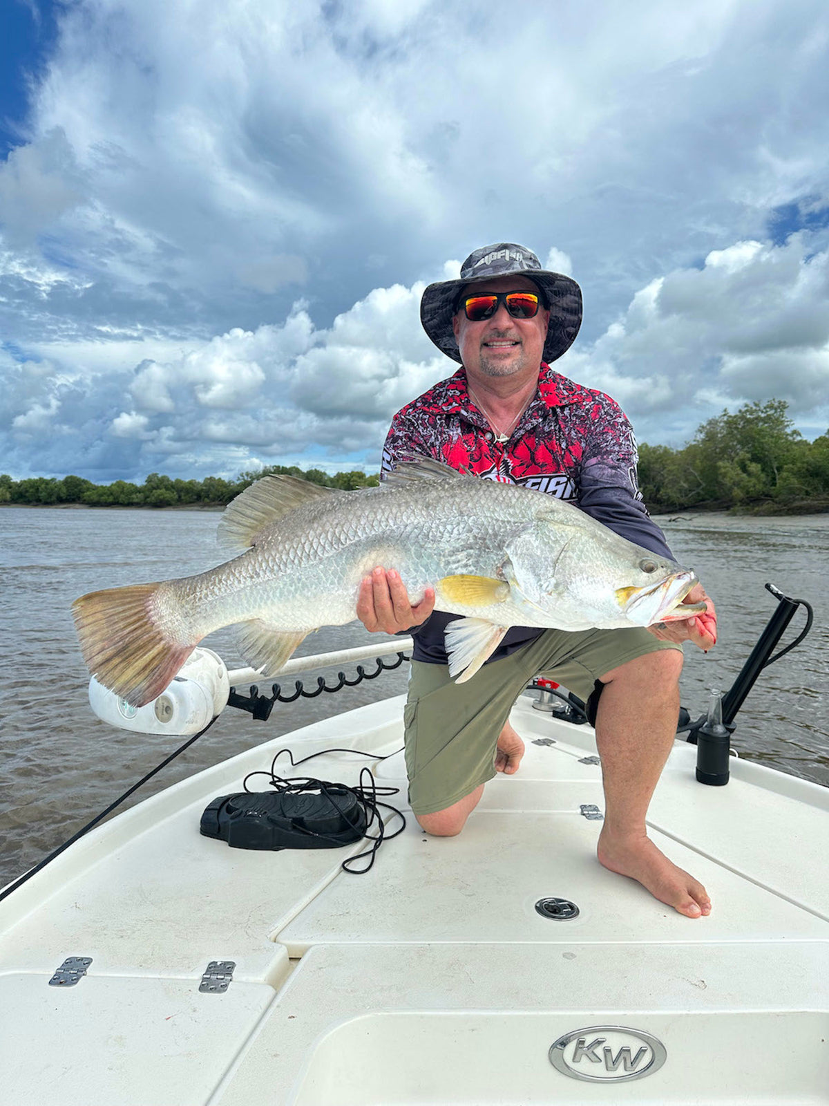 Angler with barramundi wearing Wild Scales Grey fishing shirt